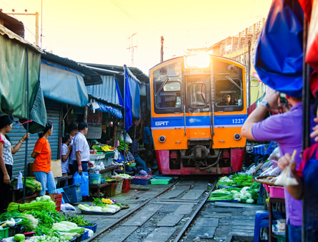 Train running through a market in Thailand